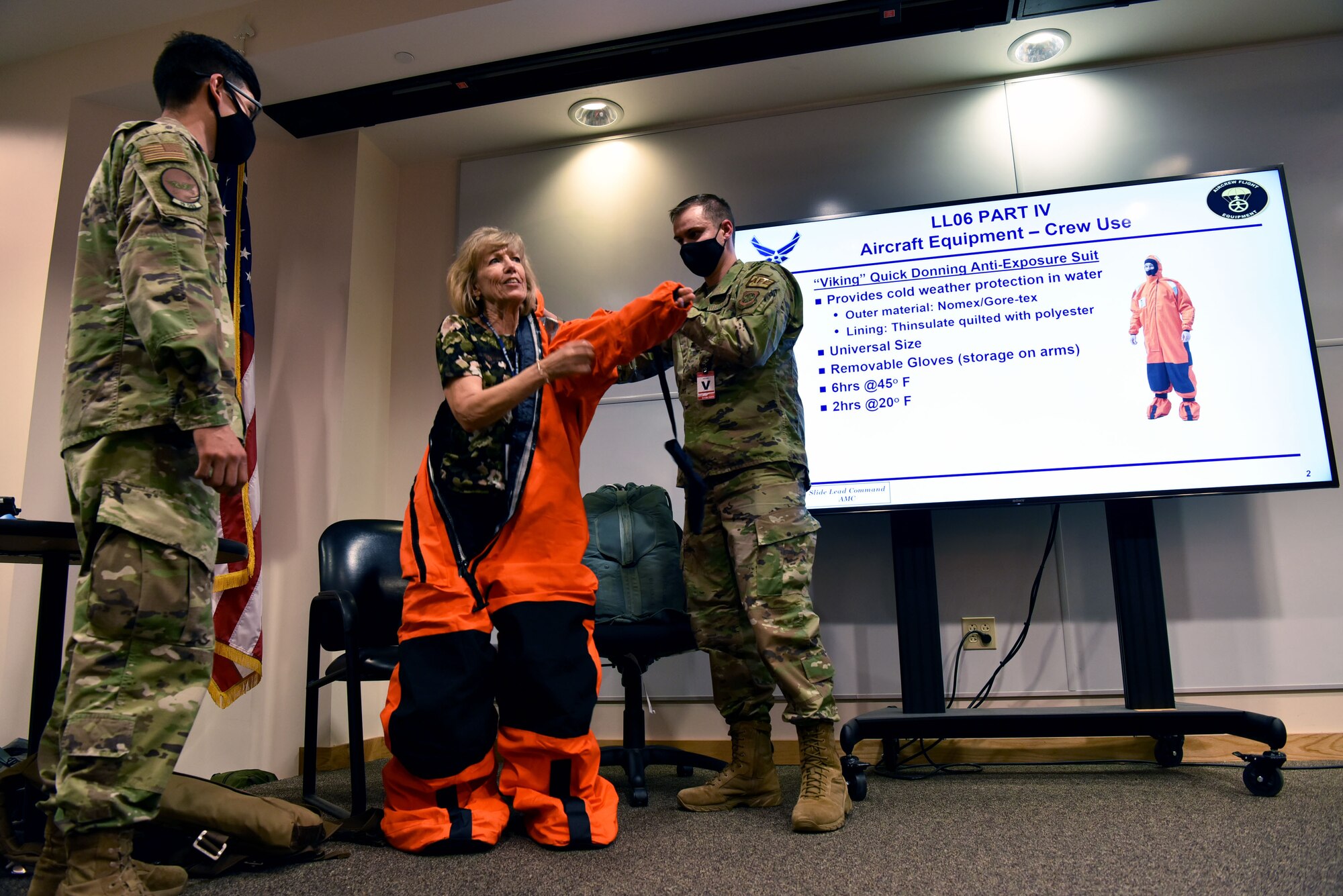Sandy Person, Air Mobility Command Civic Leader representing Travis Air Force Base, California, tries on an anti-exposure suit