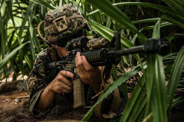 U.S. Marine Corps Cpl. Corey Slayman, a combat engineer with the Littoral Engineer Reconnaissance Team, 9th Engineer Support Battalion, 3rd Marine Logistics Group, posts security for a reconnaissance patrol during exercise Poseidon’s Watchtower on Ukibaru Island, Okinawa, Japan, June 8, 2021. Marines with 3d Marine Logistics Group and Sailors with Naval Mobile Construction Battalion 4 and UCT-2 conducted a reconnaissance of the island to hone their skills in assessing terrain for suitability of supporting maritime operations. NMCB-4 is forward deployed throughout the Indo-Pacific region and United States, ready to support major combat operations, theater security, humanitarian assistance and disaster relief operations. UCT-2 provides a capability to support a Fleet Marine Force amphibious assault, subsequent combat service support ashore, and construction, inspection, repair and maintenance of ocean facilities in support of Navy and Marine Corps operations.
