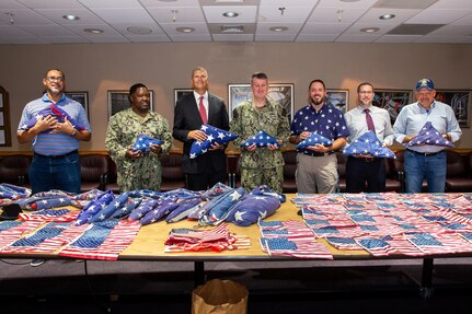 Members of the Norfolk Naval Shipyard Veteran Employee Readiness Group joined Executive Officer Capt. Todd Nichols and Command Master Chief Gene Garland in the annual Flag Day turnover, presenting 217 U.S. Flags to Sturtevant Funeral Home Representative Robie Gardner.