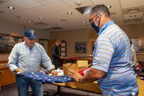 Norfolk Naval Shipyard Veteran Employee Readiness Group Vice President Michael Miller and Member Jonathan Echols fold a U.S. Flag in preparation to be turned over to Sturtevant Funeral Home as part of their Retire Your Flag Program.
