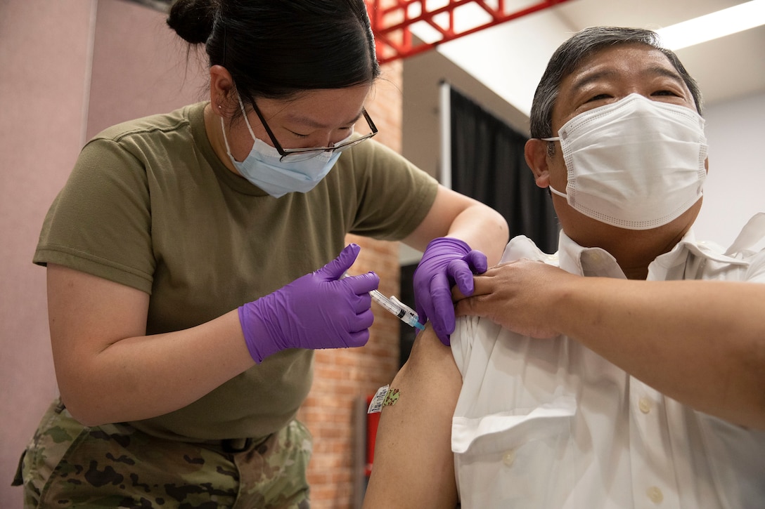 An airman administers the COVID-19 vaccine.