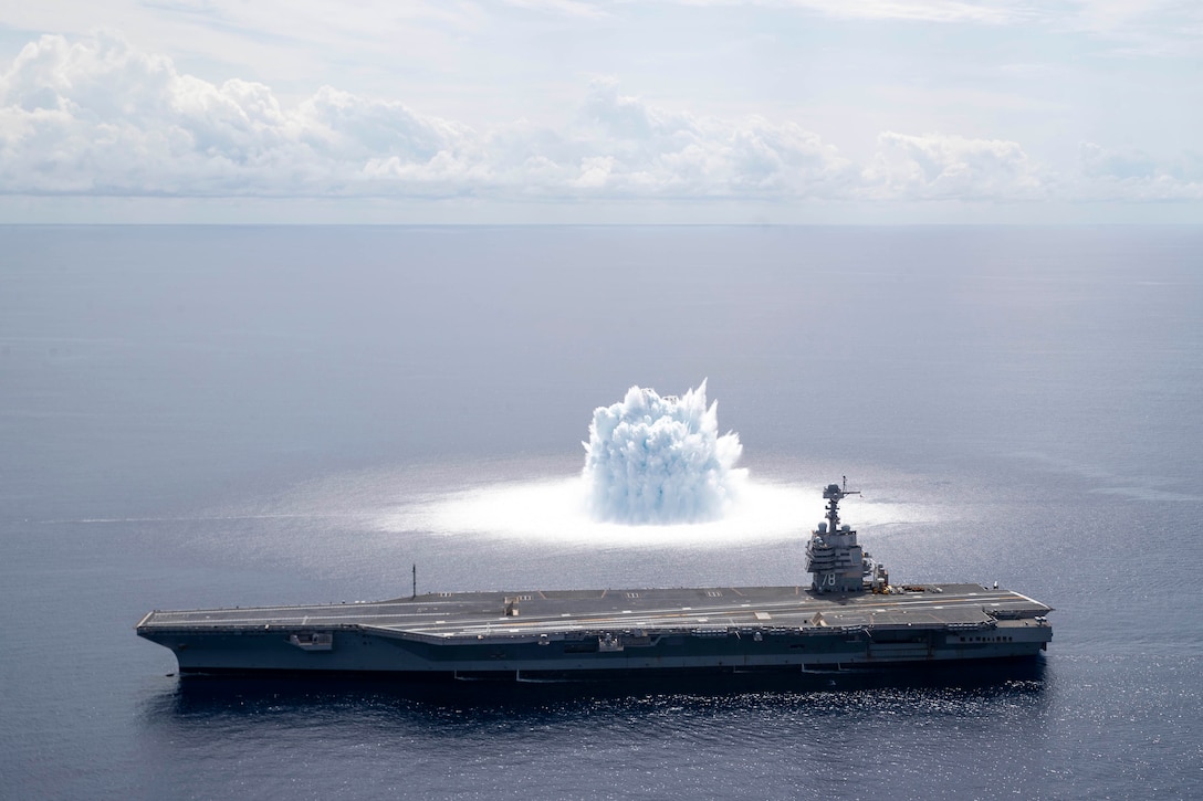 A ship transits the sea near a water explosion.