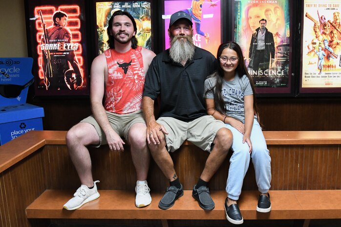 man poses with family