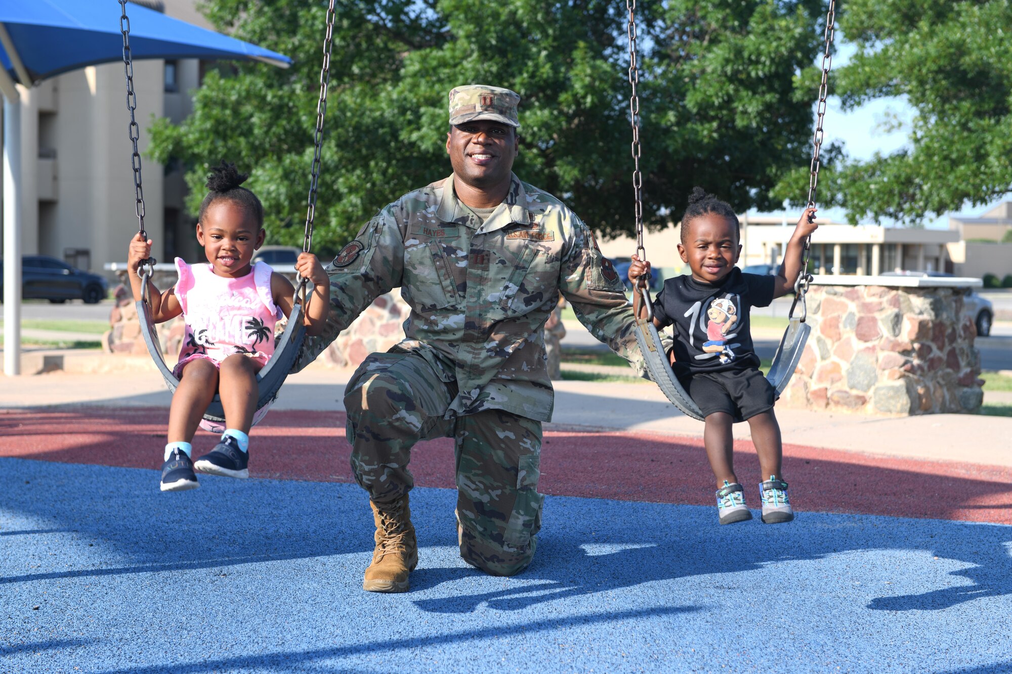 airman poses with two children