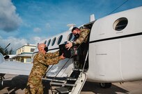 Rhode Island National Guard (RING) crewmembers load specialized coolers filled with COVID-19 vaccine doses onto a RING C-12 aircraft for distribution to the Family Islands in The Bahamas, June 21, 2021.