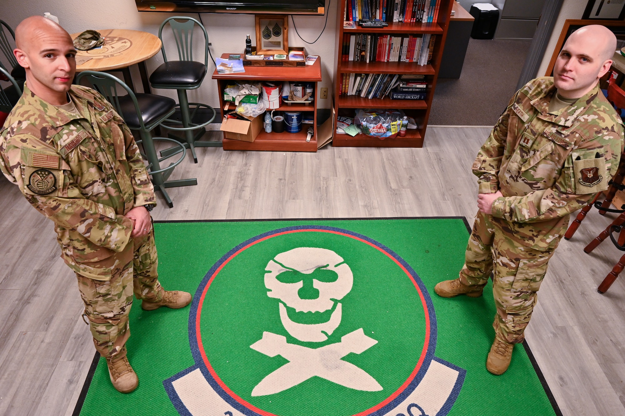 Capt. Christian Heath and 1st Lt. Juan Navarro, 321st Missile Squadron combat crew, pose in front of the 90th Operations Group emblem on F.E. Warren Air Force Base, Wyoming, June 17, 2021. The Air Force Association awarded Heath and Navarro the 2020 Gen. Thomas S. Power Outstanding Missile Crew Award. (U.S. Air Force photo by Joseph Coslett)