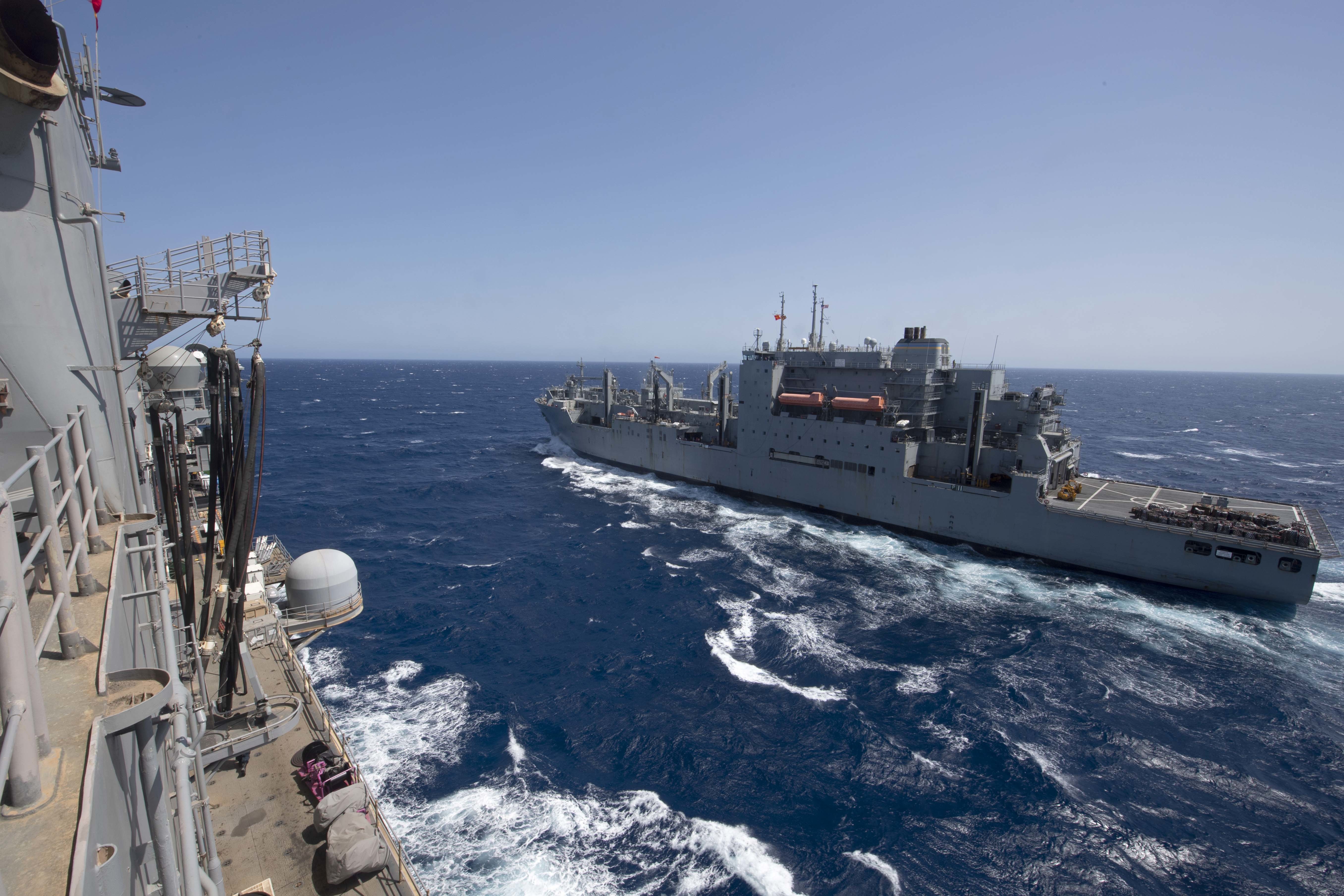The amphibious assault ship USS Iwo Jima (LHD 7), left, sails in formation with Military Sealift Command dry cargo ship USNS William McLean (T-AKE 12) during a replenishment-at-sea