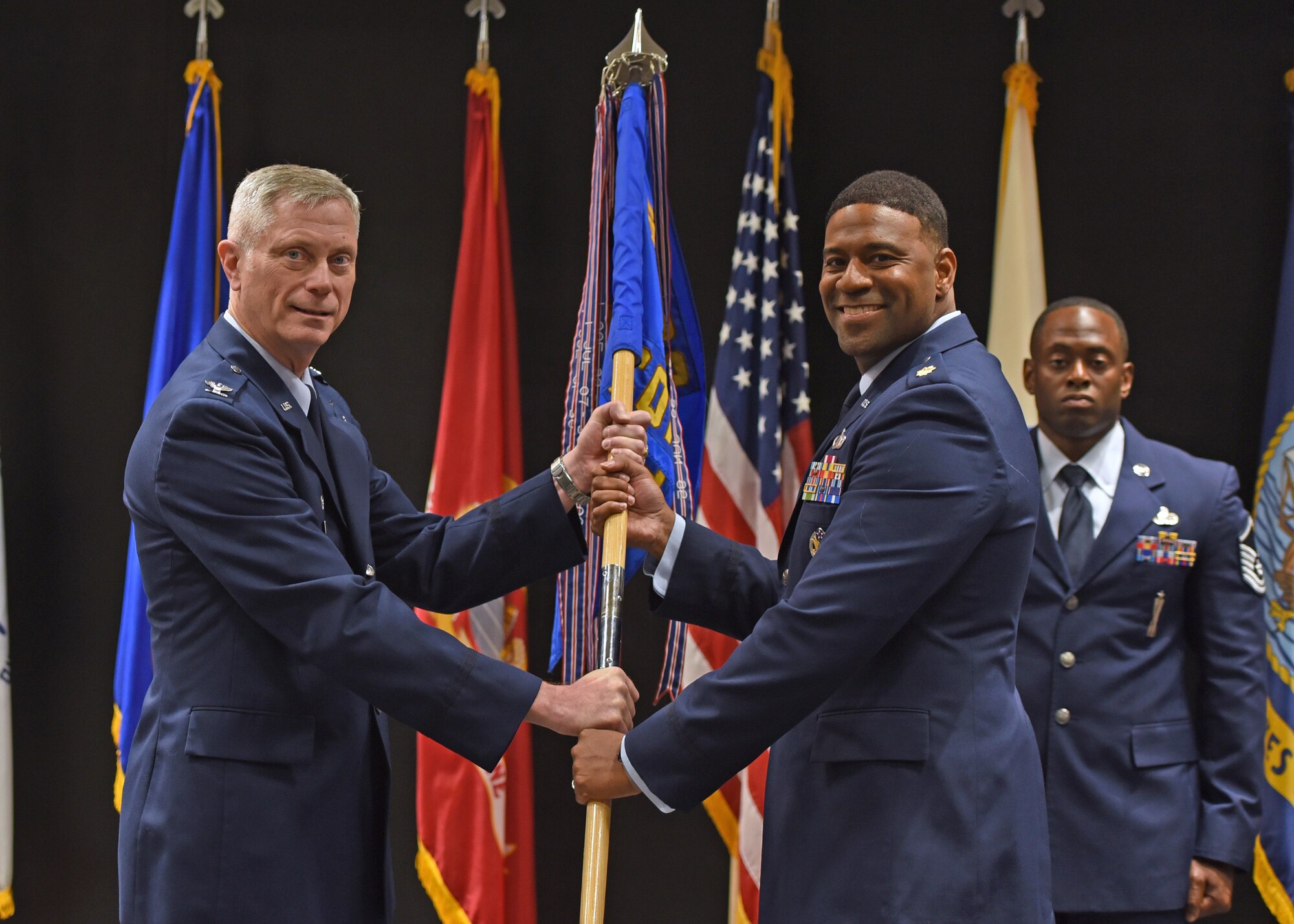 U.S. Air Force Col. Tony England, 17th Mission Support Group commander, passes the guidon to Maj. Ivan Pinder-Bey, 17th Contracting Squadron incoming commander, during the 17th CONS change of command ceremony at the Event Center, June 21, 2021. Pinder-Bey was previously student at Air Command and Staff College on Maxwell Air Force Base, Alabama. (U.S. Air Force photo by Senior Airman Abbey Rieves)