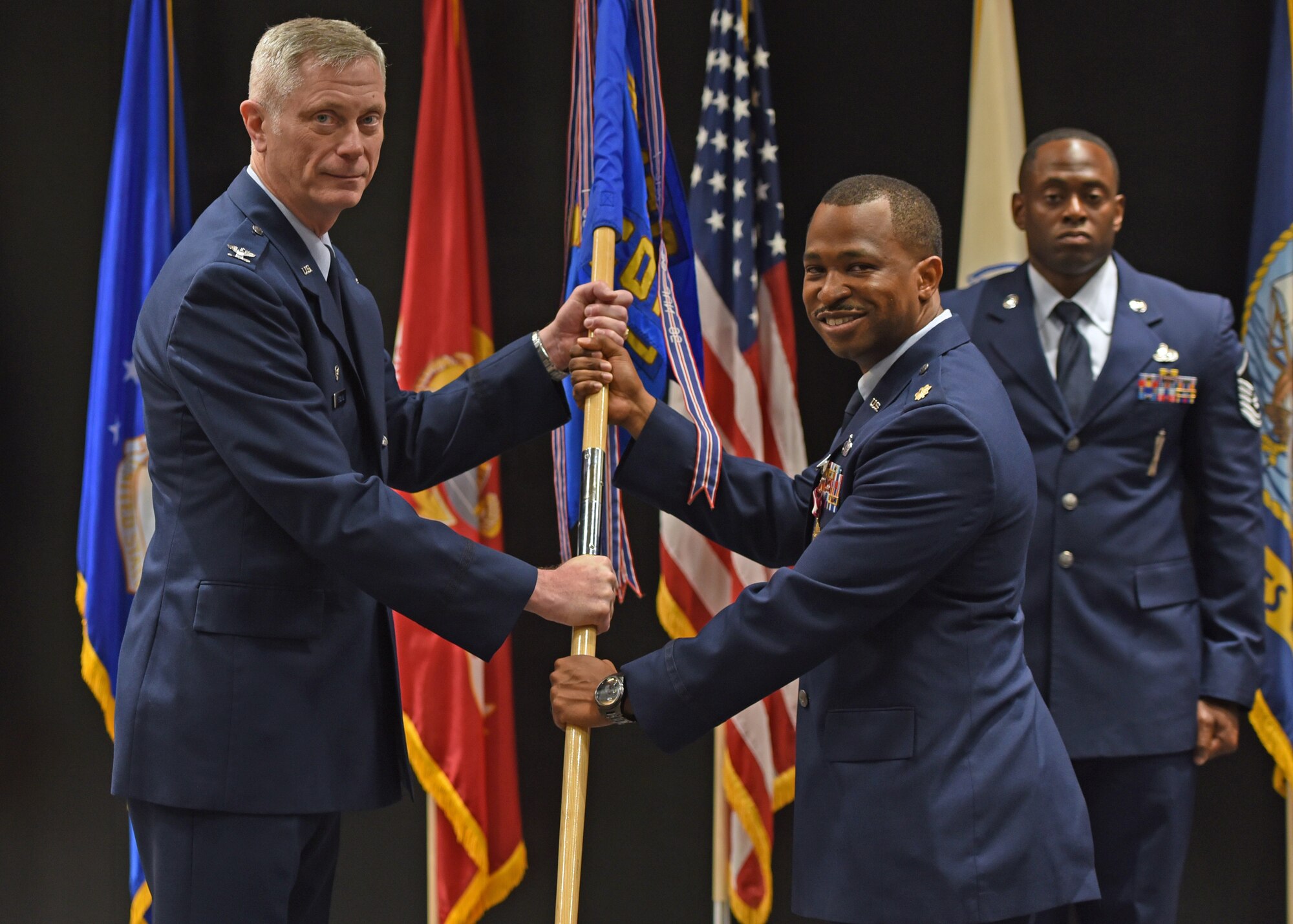 U.S. Air Force Col. Tony England, 17th Mission Support Group commander, takes the guidon from Maj. Michael Quinn, 17th Contracting Squadron outgoing commander, during the 17th CONS change of command ceremony at the Event Center, June 21, 2021. Quinn was in command of the 17th CONS for three years. (U.S. Air Force photo by Senior Airman Abbey Rieves)