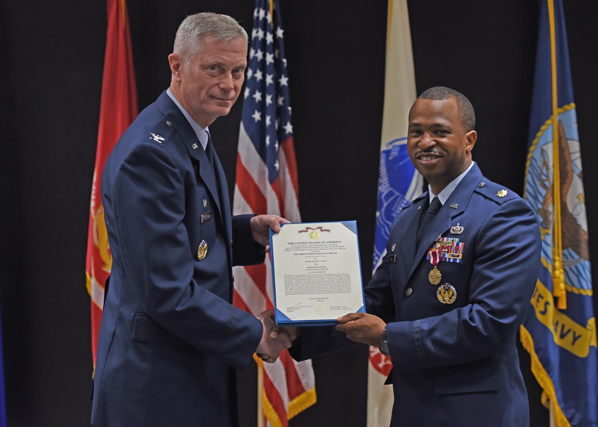 U.S. Air Force Col. Tony England, 17th Mission Support Group commander, presents Maj. Michael Quinn, 17th Contracting Squadron outgoing commander, the Meritorious Service Medal during the 17th CONS change of command ceremony at the Event Center, June 21, 2021. Quinn was decorated for overseeing $43 million in contracts to support the training, development, and education for over 14 thousand joint service students. (U.S. Air Force photo by Senior Airman Abbey Rieves)