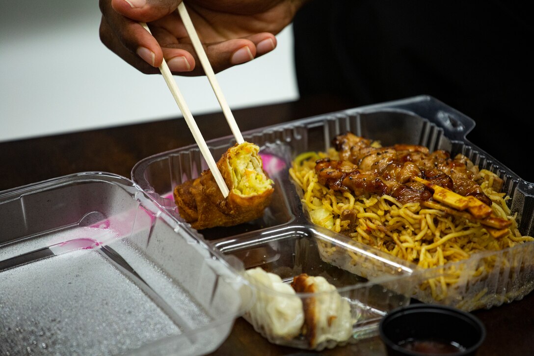 U.S. Navy sailor Petty Officer 3rd Class Micah Marshall, religious program specialist, 3rd Reconnaissance, 3d Marine Division, enjoys Japanese food at the Camp Schwab Single Marine Program Center June 18, 2021 on Camp Schwab, Okinawa, Japan. The Camp Schwab SMP Center provided traditional Japanese food to Single Marines and greenside sailors to celebrate International Sushi Day which is held on the 18th of June to commemorate the Japanese delicacy. The form of sushi containing fish, vegetables, rice and seaweed people enjoy today, originates back to 1600 AD during Japan’s Edo period.  Marshall is a Pittsburgh, Pennsylvania native. (U.S. Marine Corps photo by Staff Sgt. Lucas Vega)