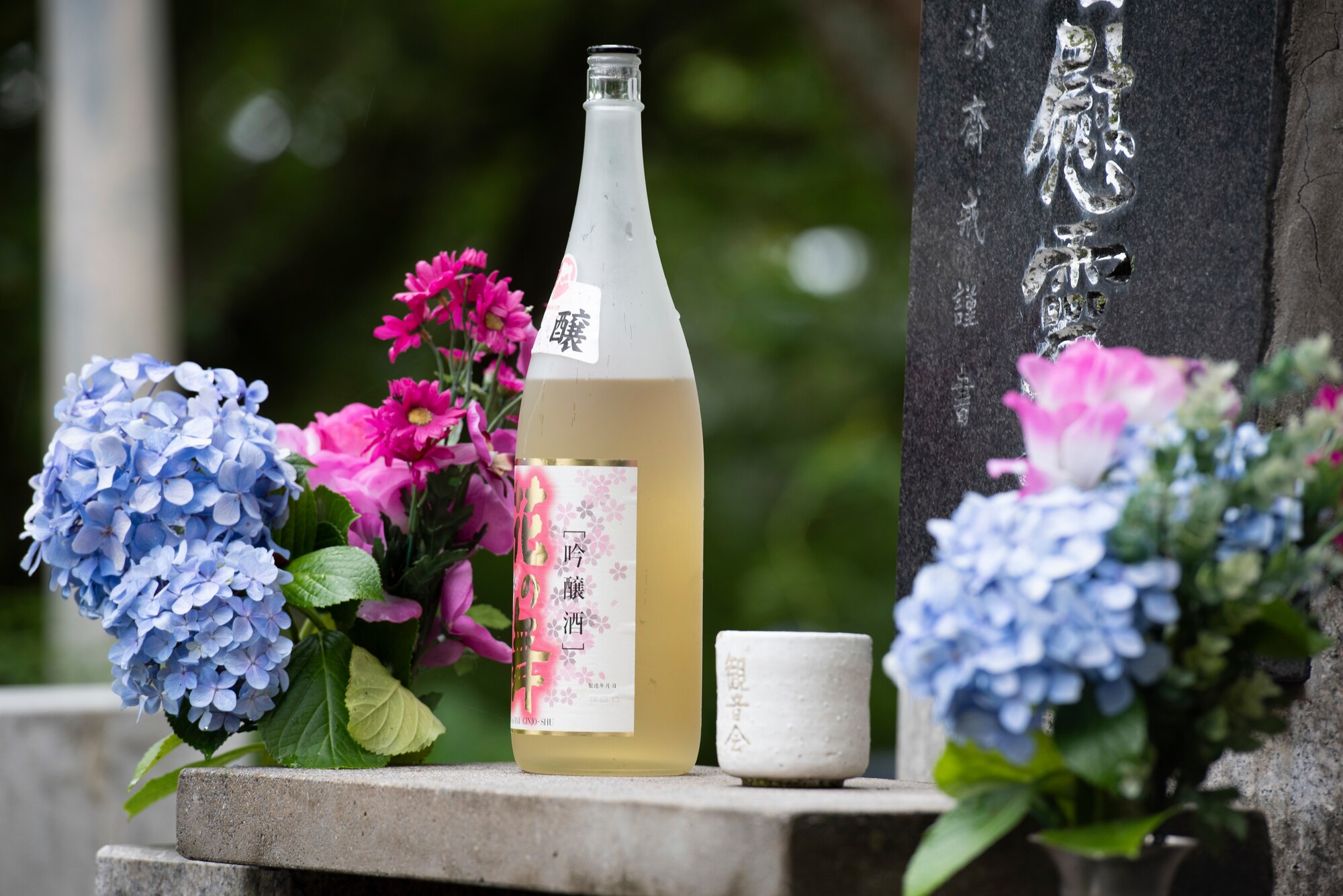 An offering of sake and flowers rests on an altar prior to a memorial ceremony in Shizuoka City, Japan, June 19, 2021. The ceremony honored the 23 crew members and approximately 2,000 Japanese citizens that died during an air raid and when two B-29 Superfortesses collided, during World War II. (U.S. Air Force photo by Staff Sgt. Joshua Edwards)