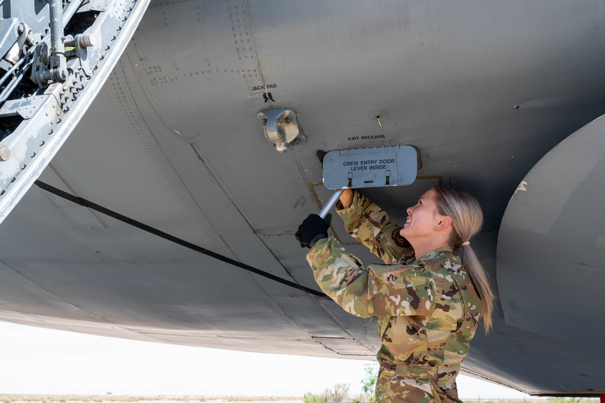 Airman 1st Class Rebecca Reimer, 9th Airlift Squadron loadmaster student, opens the crew entry door panel of a Dover Air Force Base C-5M Super Galaxy during a Major Command Service Tail Trainer exercise at Holloman AFB, New Mexico, June 2, 2021. The 9th AS performs MSTTs to expedite upgrade and qualification training for C-5M loadmasters and flight engineers. Of the 350 tasks needed to be a fully qualified loadmaster, roughly half can be completed during an MSTT, reducing training time by up to 35 days. (U.S. Air Force photo by Senior Airman Faith Schaefer)