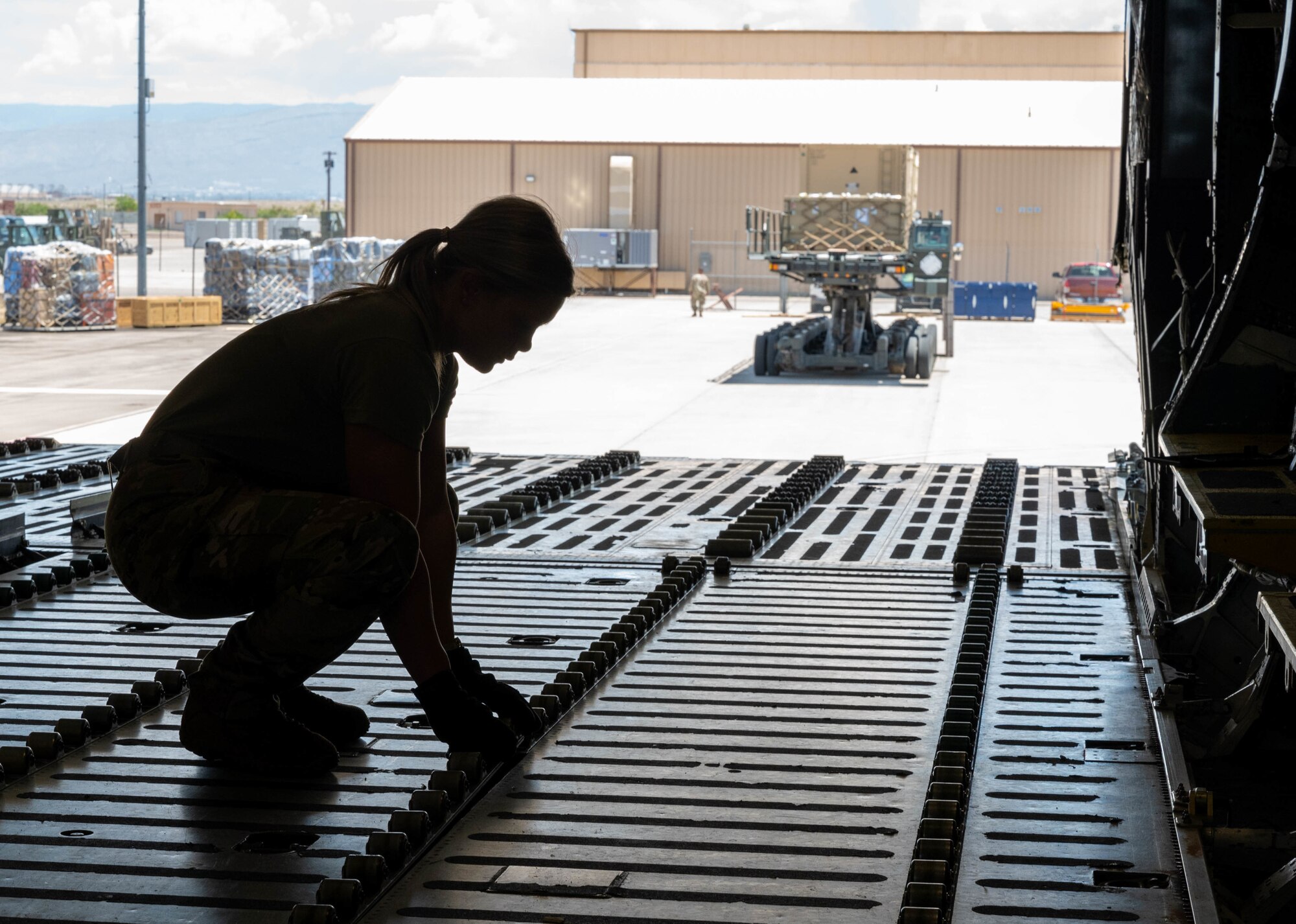 Airman 1st Class Rebecca Reimer, 9th Airlift Squadron loadmaster student, secures rollers to the cargo deck of a Dover Air Force Base C-5M Super Galaxy during a Major Command Service Tail Trainer exercise at Holloman AFB, New Mexico, June 2, 2021. The 9th AS performs MSTTs to expedite upgrade and qualification training for C-5M loadmasters and flight engineers. Over the course of the 10-day MSTT, 9th AS loadmasters loaded and unloaded 320,085 pounds of cargo, including palletized cargo, aircraft ground equipment, a fuel truck and a K-loader. (U.S. Air Force photo by Senior Airman Faith Schaefer)
