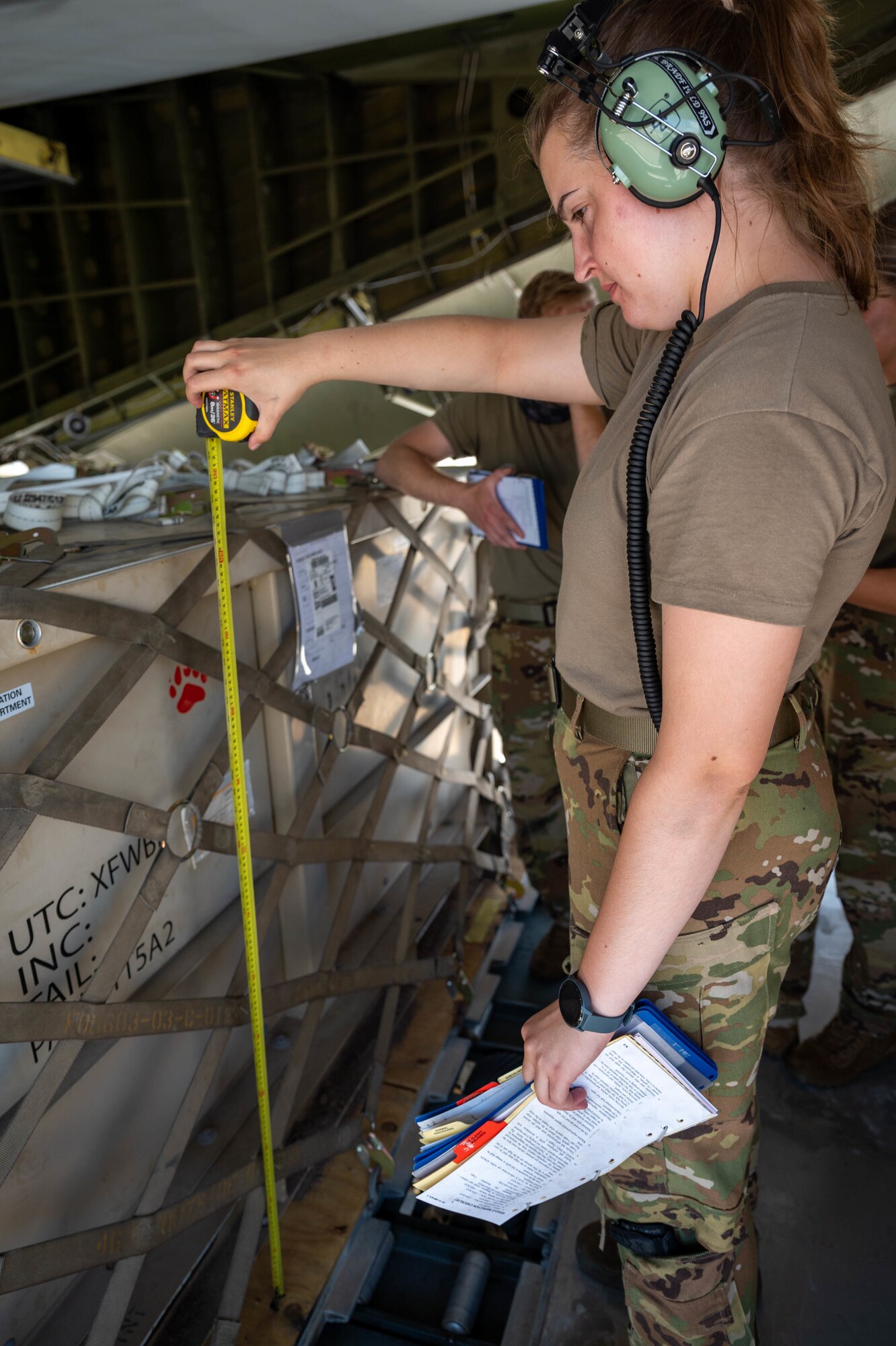 Senior Airman Amelia Bradfield, 9th Airlift Squadron loadmaster, measures the height of a cargo box before loading it onto a Dover Air Force Base C-5M Super Galaxy during a Major Command Service Tail Trainer exercise at Holloman AFB, New Mexico, June 2, 2021. The 9th AS performs MSTTs to expedite upgrade and qualification training for C-5M loadmasters and flight engineers. Over the course of the 10-day MSTT, 9th AS loadmasters loaded and unloaded 320,085 pounds of cargo, including palletized cargo, aircraft ground equipment, a fuel truck and a K-loader. (U.S. Air Force photo by Senior Airman Faith Schaefer)
