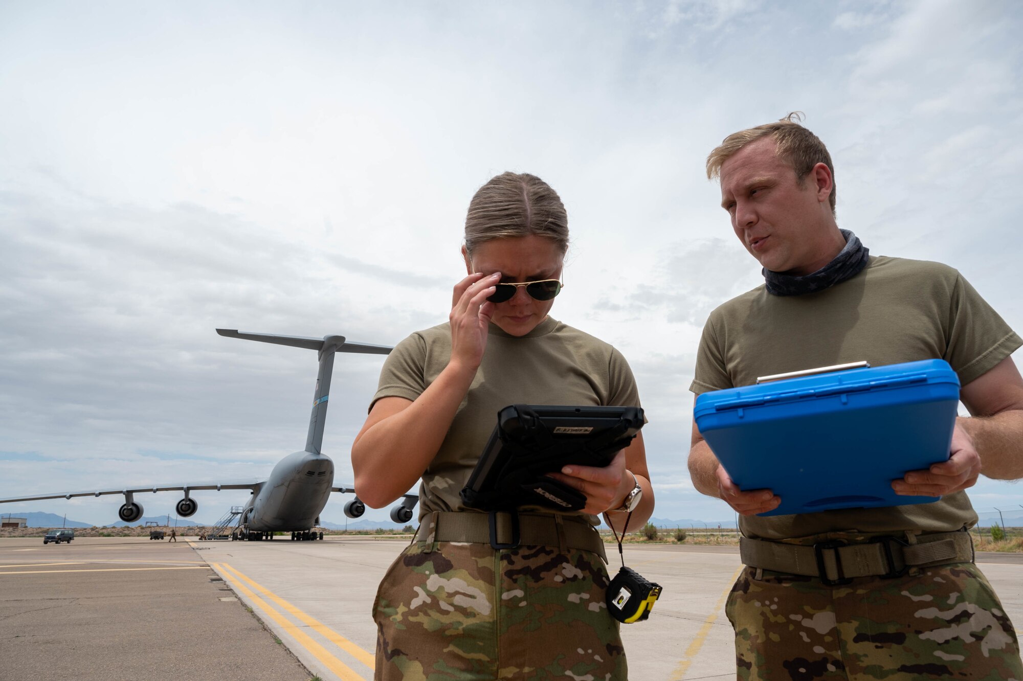 Airman 1st Class Rebecca Reimer, left, 9th Airlift Squadron student loadmaster, and Staff Sgt. Justin Thomas, 9th AS noncommissioned officer in charge of loadmaster training, discuss a joint inspection checklist during a Major Command Service Tail Trainer at Holloman Air Force Base, New Mexico, June 2, 2021. The 9th AS performs MSTTs to expedite upgrade and qualification training for C-5M loadmasters and flight engineers. Of the 350 tasks needed to be a fully qualified loadmaster, roughly half can be completed during an MSTT,  reducing training time by up to 35 days. (U.S. Air Force photo by Senior Airman Faith Schaefer)
