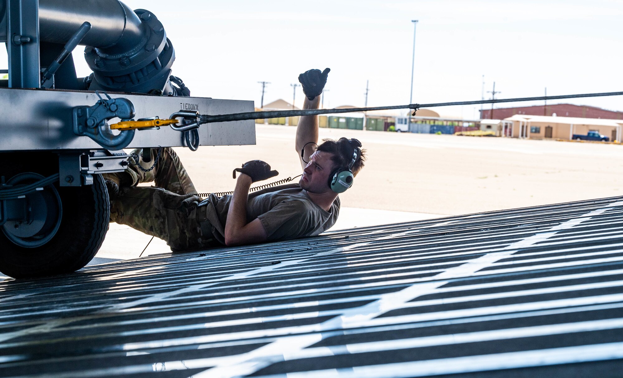 Staff Sgt. John Dittess, 9th Airlift Squadron loadmaster, assists in marshaling aircraft ground equipment onto a Dover Air Force Base C-5M Super Galaxy during a Major Command Service Tail Trainer, at Holloman AFB, June 8, 2021. Loadmasters from the 9th AS coordinated cargo with Airmen from Air Education and Training Command’s 49th Wing and Air Force Materiel Command’s 635th Material Maintenance Group to complete the 10-day MSTT. Over the course of the training, Airmen loaded and unloaded 320,085 pounds of cargo, including palletized cargo, AGE, a fuel truck and a K-loader. (U.S. Air Force photo by Senior Airman Faith Schaefer)