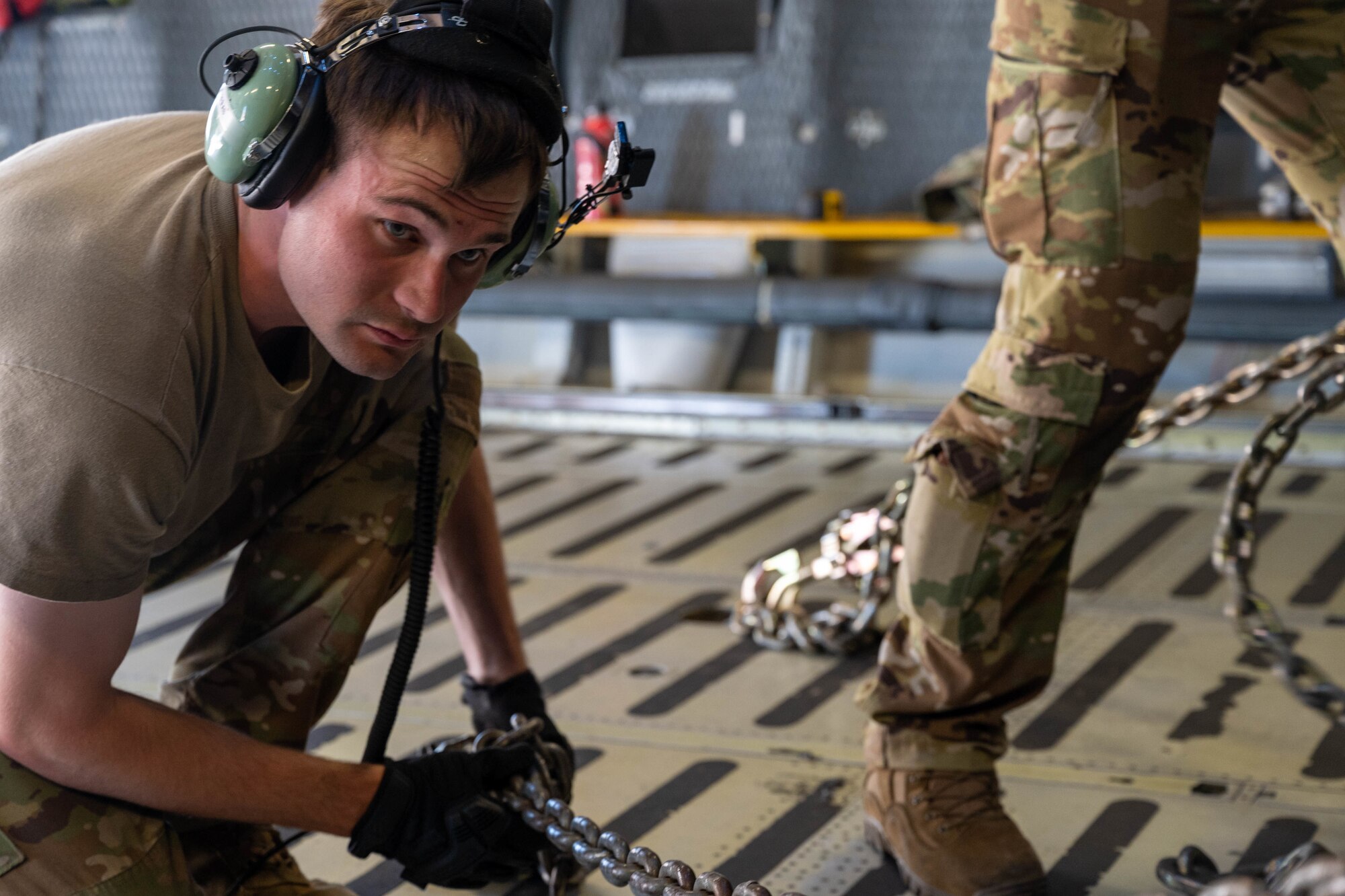 Staff Sgt. John Dittess, 9th Airlift Squadron loadmaster, chains a K-loader to the cargo compartment of a Dover Air Force Base C-5M Super Galaxy during a Major Command Service Tail Trainer at Holloman AFB, June 9, 2021. Loadmasters from the 9th AS coordinated cargo with Airmen from Air Education and Training Command’s 49th Wing and Air Force Materiel Command’s 635th Materiel Maintenance Group to complete the 10-day MSTT. Over the course of the training, Airmen loaded and unloaded 320,085 pounds of cargo, including palletized cargo, aircraft ground equipment, a fuel truck and a K-loader. (U.S. Air Force photo by Senior Airman Faith Schaefer)