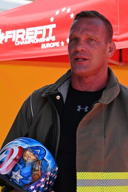After completing numerous course runs throughout the week, Master Sgt. Sean Sullivan, assistant chief of training in the 445th Civil Engineer Squadron, stops after his final course completion on June 20, 2021 to congratulate other competitors and speak with community members and local media while awaiting the closing ceremonies at the FireFit Europe Championships in Hannover, Germany. (U.S. Air Force photo/Capt. Rachel Ingram)