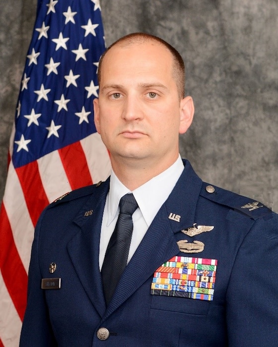 Photo of Colonel Adam Shelton in front of U.S. flag