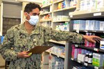 Service member reaches for medicine in pharmacy