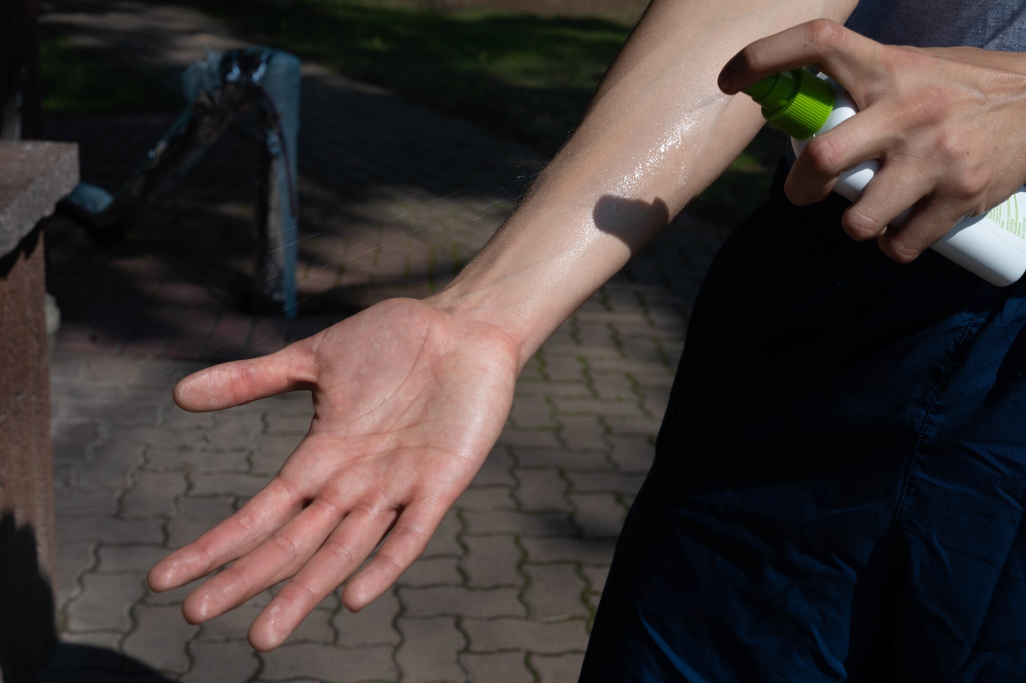 Airman applies insect repellent to arm.