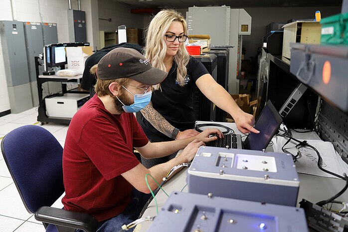 IMAGE: Lauren Sencio, Ship Self Defense System Hardware Design Task Planning Lead, and Kevin Newcomer, an SSDS Hardware Design Team computer engineer, test a 3D-printed arming unit May 25, at Naval Surface Warfare Center Dahlgren Division Dam Neck Activity in Virginia Beach, Virginia. The SSDS Hardware Design Team worked with DNA’s FIRE Lab to 3D print the arming unit—a component of the SSDS Command Control Group console—to speed up design validation for the prototype.