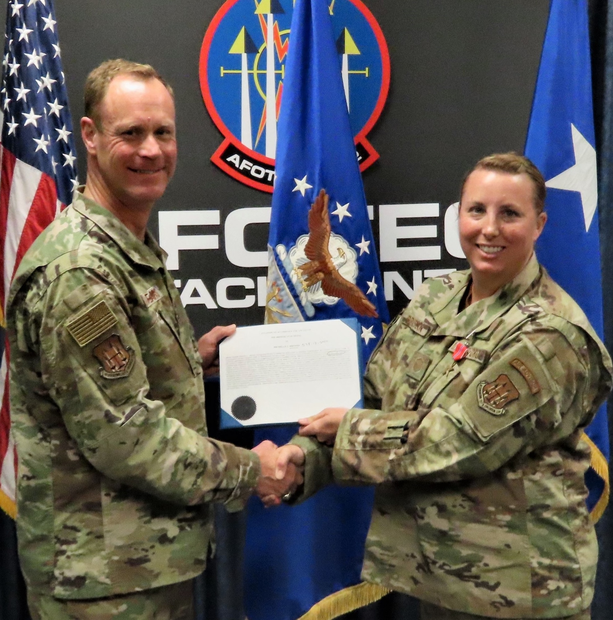 Air Force Operational Test and Evaluation Center Commander Maj. Gen. James R. Sears Jr., presents Master Sgt. Michelle Bresson the Bronze Star Medal for meritorious achievement while deployed to Afghanistan.