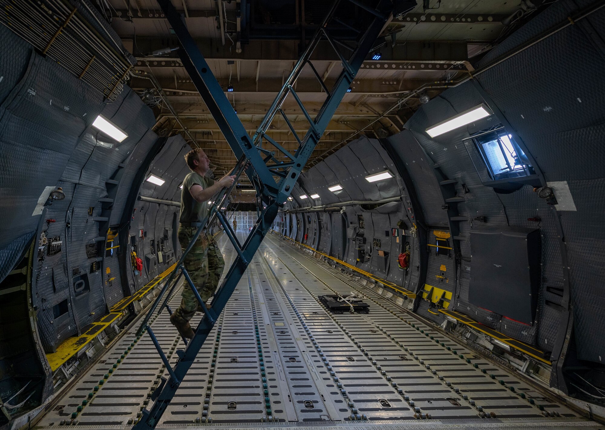 Staff Sgt. Justin Thomas, 9th Airlift Squadron noncommissioned officer in charge of loadmaster training, climbs the troop deck stairs of a Dover Air Force Base C-5M Super Galaxy during a Major Command Service Tail Trainer at Holloman AFB, New Mexico, June 4, 2021. The 9th AS performs MSTTs to expedite upgrade and qualification training for C-5M loadmasters and flight engineers. Of the 350 tasks needed to be a fully qualified loadmaster, roughly half can be completed during an MSTT, reducing the time of training by up to 35 days. (U.S. Air Force photo by Senior Airman Faith Schaefer)