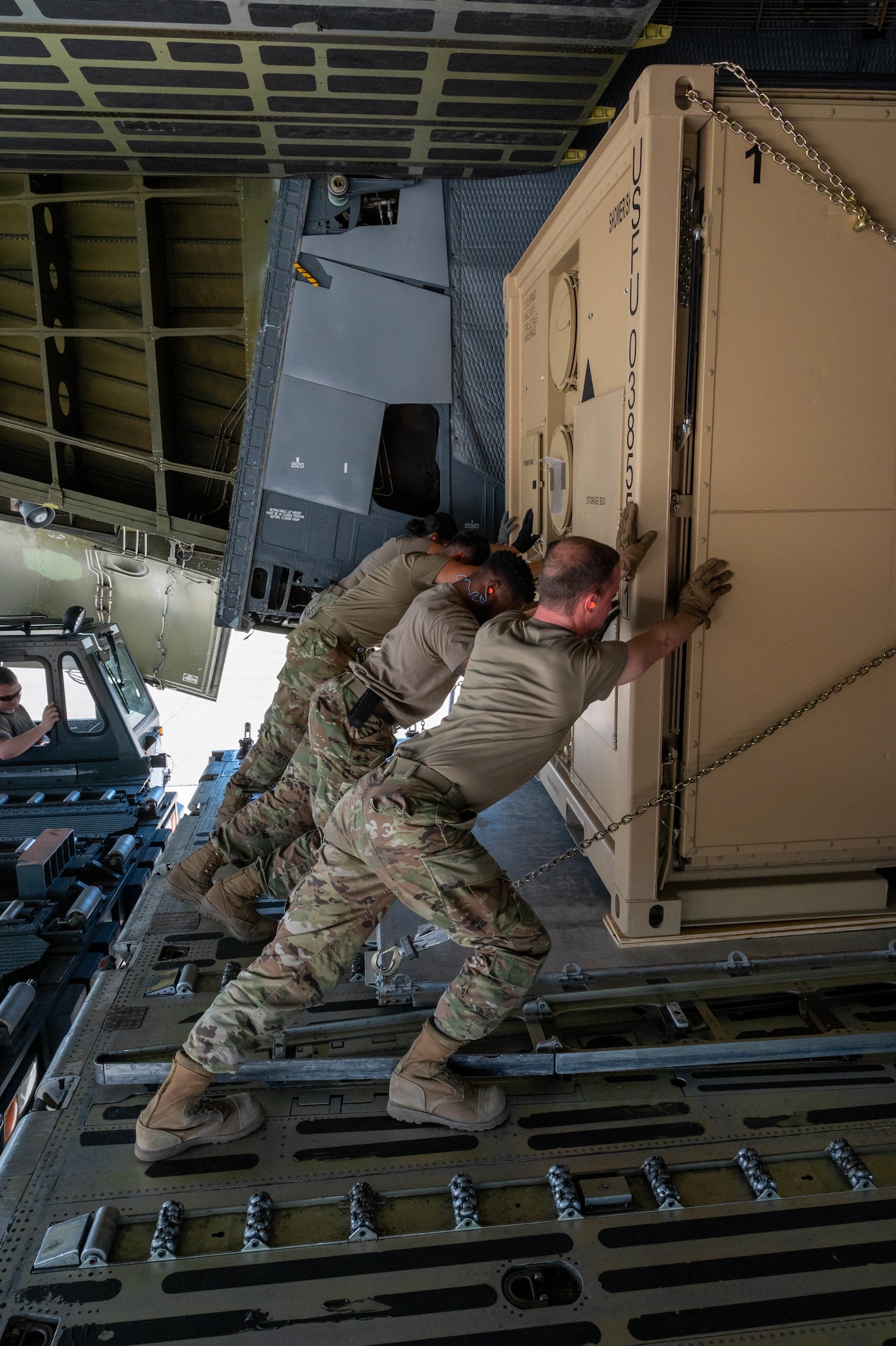 Airmen from the 635th Materiel Maintenance Group push palletized cargo onto a Dover Air Force Base C-5M Super Galaxy during a Major Command Service Tail Trainer exercise at Holloman AFB, New Mexico, June 2, 2021. Loadmasters from the 9th Airlift Squadron coordinated cargo with Air Education and Training Command’s 49th Wing and Air Force Materiel Command’s 635th MMG Airmen to complete the 10-day MSTT. During the training, Airmen loaded and unloaded 320,085 pounds of cargo, including palletized cargo, aircraft ground equipment, a fuel truck and a K-loader. (U.S. Air Force photo by Senior Airman Faith Schaefer)