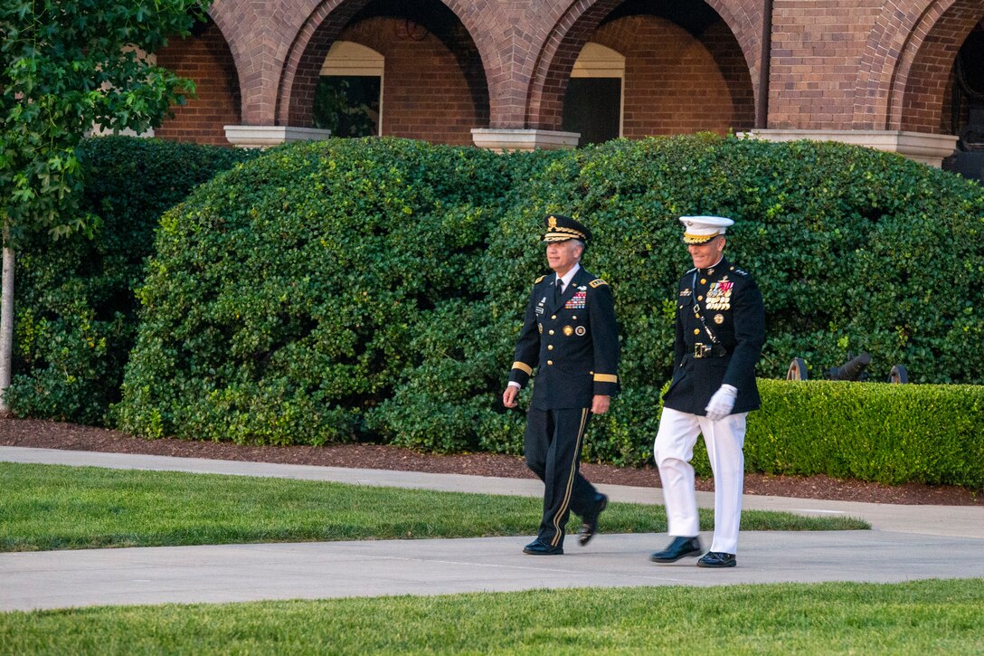 U.S. Army General Paul M. Nakasone, USA Commander of United States Cyber Command, Director of the National Security Agency and Chief of the Central Security Service, and U.S. Marine Corps Lt. Gen. George W. Smith Jr., Deputy Commandant for Plans, Policies and Operations, walk down Center Walk during a Friday Evening Parade at Marine Barracks Washington, June 18, 2021. The hosting official for the evening was Lt. Gen. Smith, and Gen. Nakasone was the guest of honor. (U.S. Marine Corps photo by Lance Cpl. Mark Morales)
