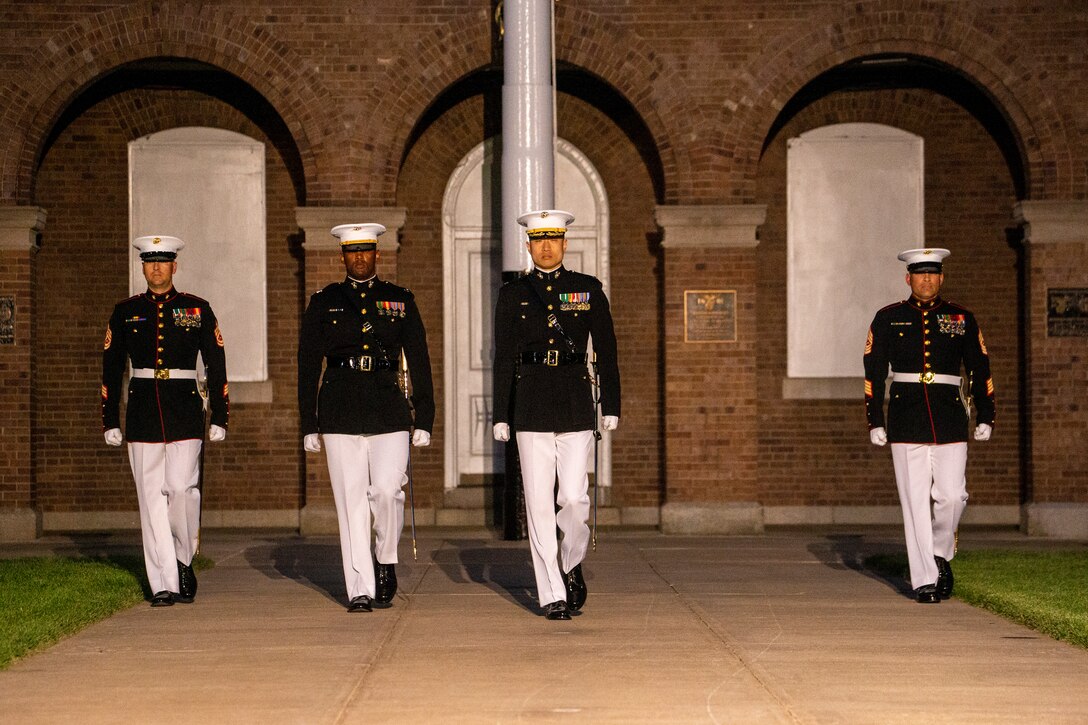Marines with the Marine Barracks Washington parade staff march down center walk during a Friday Evening Parade at Marine Barracks Washington, June 18, 2021. U.S. Marine Corps Lt. Gen. George W. Smith Jr., Deputy Commandant for Plans, Policies and Operations, was the hosting official and U.S. Army General Paul M. Nakasone, USA Commander of United States Cyber Command, Director of the National Security Agency and Chief of the Central Security Service, was the guest of honor. (U.S. Marine Corps photo by Lance Cpl. Allen Sanders)