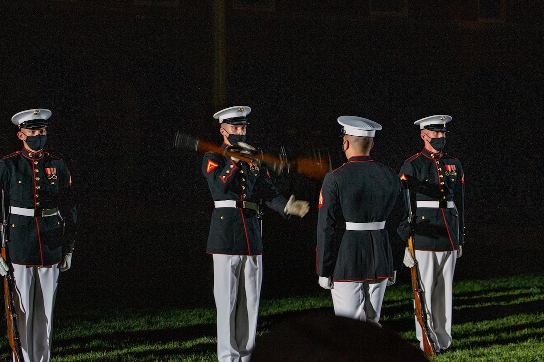 Marines with the Silent Drill Platoon execute their “rifle inspection” sequence during a Friday Evening Parade at Marine Barracks Washington, June 18, 2021. U.S. Marine Corps Lt. Gen. George W. Smith Jr., Deputy Commandant for Plans, Policies and Operations, was the hosting official and U.S. Army General Paul M. Nakasone, USA Commander of United States Cyber Command, Director of the National Security Agency and Chief of the Central Security Service, was the guest of honor. (U.S. Marine Corps photo by Lance Cpl. Allen Sanders)