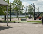 Workers take apart COVID-19 testing tents, June 15, which were put up in March 2020 to provide car triage screening for the virus.