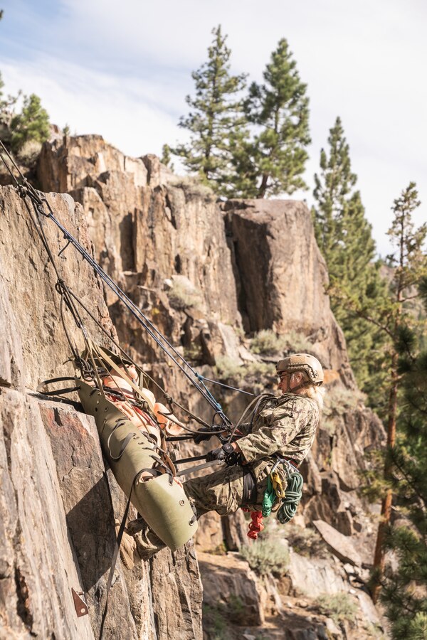 U.S. Navy Ensign Ann Zingsheim, an emergency room nurse with Naval Medical Center Portsmouth, lowers a rescue stretcher down a cliff at the Mountain Warfare Training Center, Bridgeport, California, on June 16, 2021. U.S. Sailors, Soldiers and Marines learned how to use rope systems to transport themselves and patients through technical terrain during the Mountain Medicine Course. (U.S. Marine Corps photo by Lance Cpl. Andrew R. Bray)