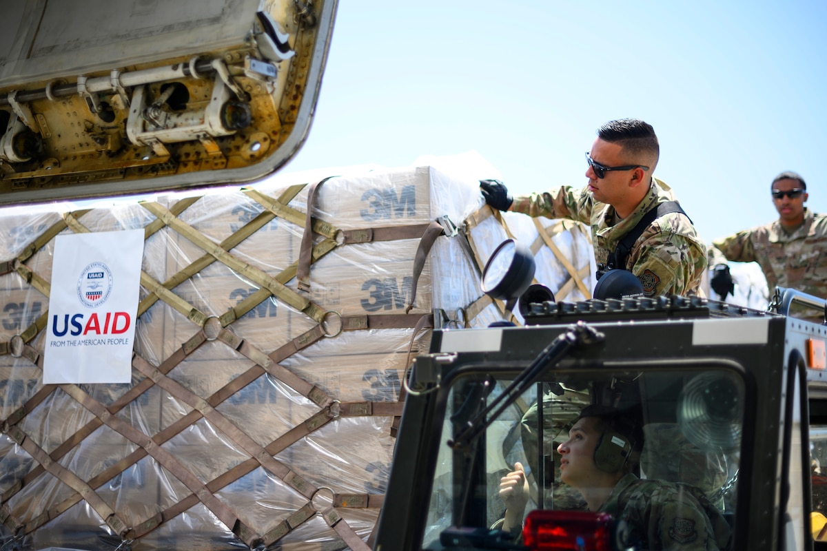 Airmen load a shipment of pallets onto an aircraft.