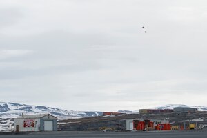 Two jets fly over an Arctic air field.