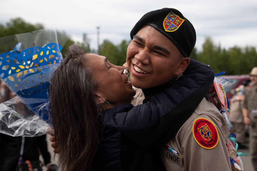 An Alaska Military Youth Academy cadet embraces his family after AMYA's graduation ceremony, held at the Bartlett High School Football Field in Anchorage, June 18, 2021. The ceremony featured Alaska Lt. Gov. Kevin Meyer as the keynote speaker for the 79 graduating cadets and their families. (U.S Army National Guard photo by Victoria Granado)