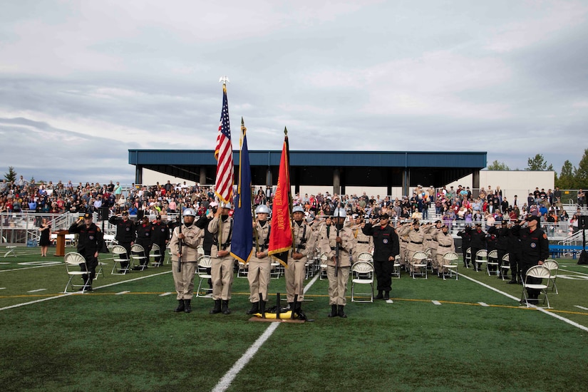 The Alaska Military Youth Academy color guard team presents the colors while the national anthem plays during AMYA's graduation ceremony, held at the Bartlett High School Football Field in Anchorage, June 18, 2021. The ceremony featured Alaska Lt. Gov. Kevin Meyer as the keynote speaker for the 79 graduating cadets and their families. (U.S Army National Guard photo by Victoria Granado)