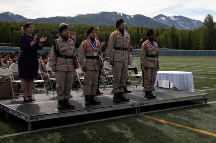 Alaska Military Youth Academy cadets stand for applause after receiving awards at AMYA's graduation ceremony, held at the Bartlett High School Football Field in Anchorage, June 18, 2021. The ceremony featured Alaska Lt. Gov. Kevin Meyer as the keynote speaker for the 79 graduating cadets and their families. (U.S Army National Guard photo by Victoria Granado)