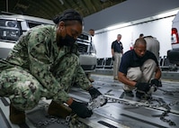 FORT LEE, Va. (June 22, 2021) Navy Personnel Specialist 2nd Class Calisia Reid Mattis and Darrion Bostick, both assigned to Joint Task Force Civil Support, practice securing forward command element vehicles in a C-17 Globemaster III load trainer during Exercise Lightning Response on Fort Lee, Virginia, June 22, 2021.