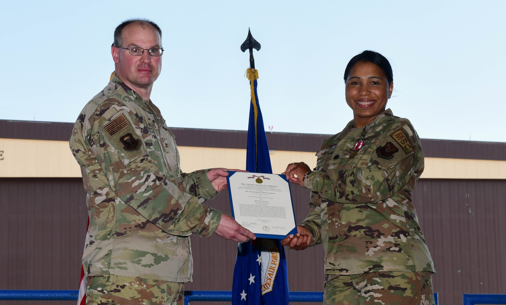 During the ceremony, Col. Mark Reynolds, 509th Medical Group commander, passed the unit flag to Lt. Col. Jessica Dees as a symbol of the continuity of authority between the outgoing and incoming commanders. (U.S. Air Force photo by Tech. Sgt. Heather Salazar)