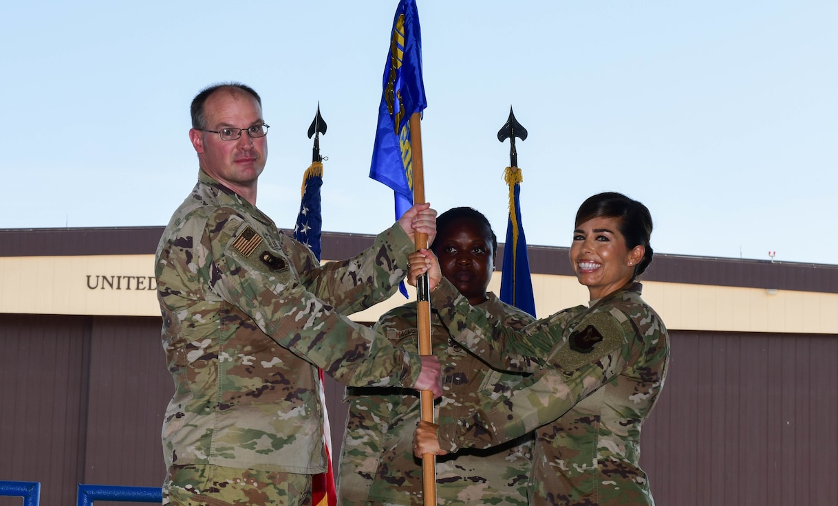 During the ceremony, Col. Mark Reynolds, 509th Medical Group commander, passed the unit flag to Lt. Col. Jessica Dees as a symbol of the continuity of authority between the outgoing and incoming commanders. (U.S. Air Force photo by Tech. Sgt. Heather Salazar)