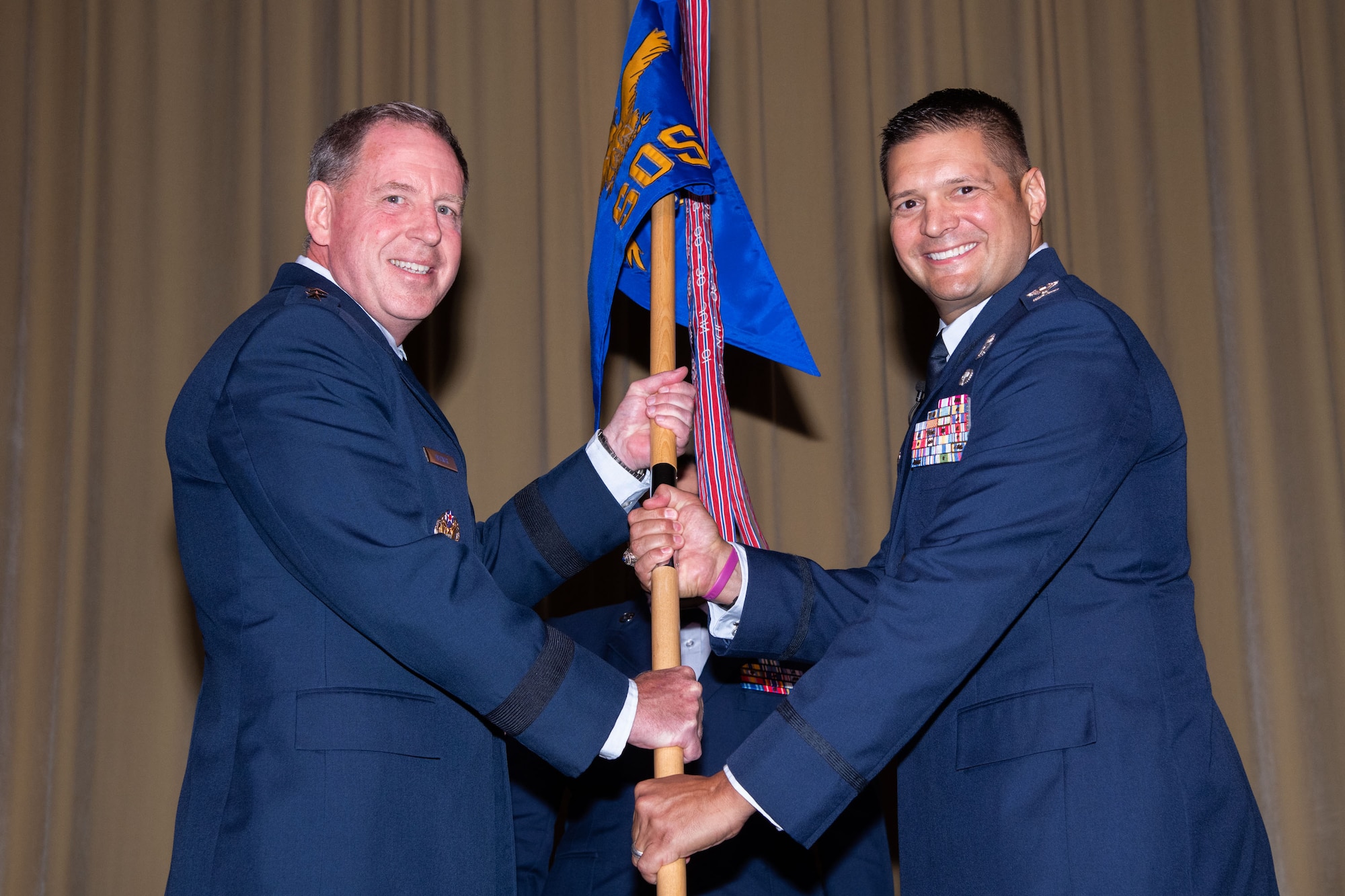 Maxwell AFB, Ala. - Lt Gen James Hecker commander and president, passes the unit guidon to incoming Squadron Officer School Commander Col. Lance Rosa-Miranda at the SOS Assumption of Command Ceremony held June 21, 2021, at Maxwell Air Force Base, Alabama. (U.S. Air Force photo by William Birchfield)