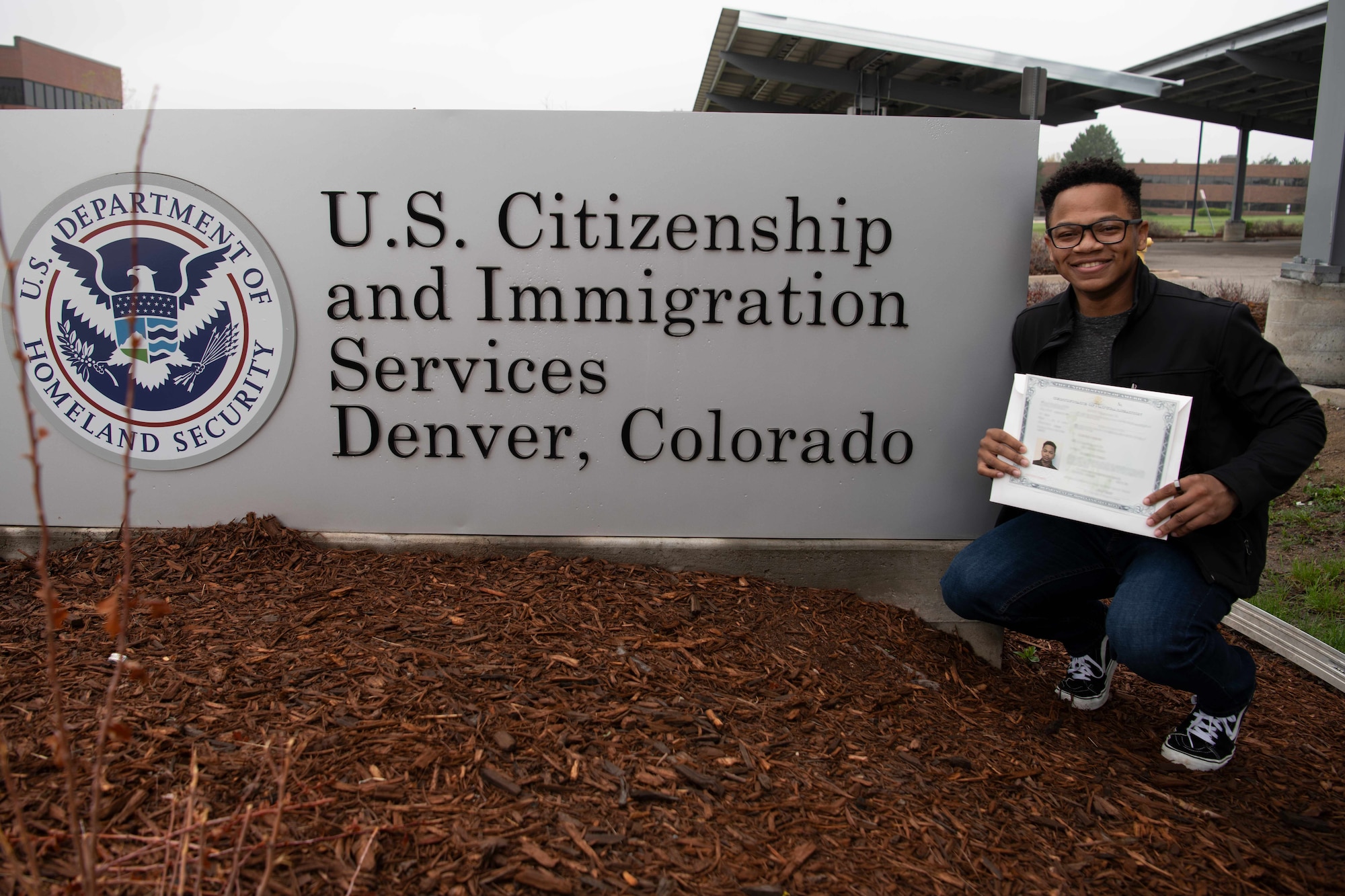 Airman 1st Class Alex Fennell, command support staff technician, 90th Medical Group, displays his certificate of naturalization outside of U.S. Citizenship and Immigration Services, Denver, Colorado, May 18, 2021. Fennell was born in Jamaica and moved to the United States to live a better life. (U.S. Air Force photo illustration by Airman 1st Class Charles Munoz)
