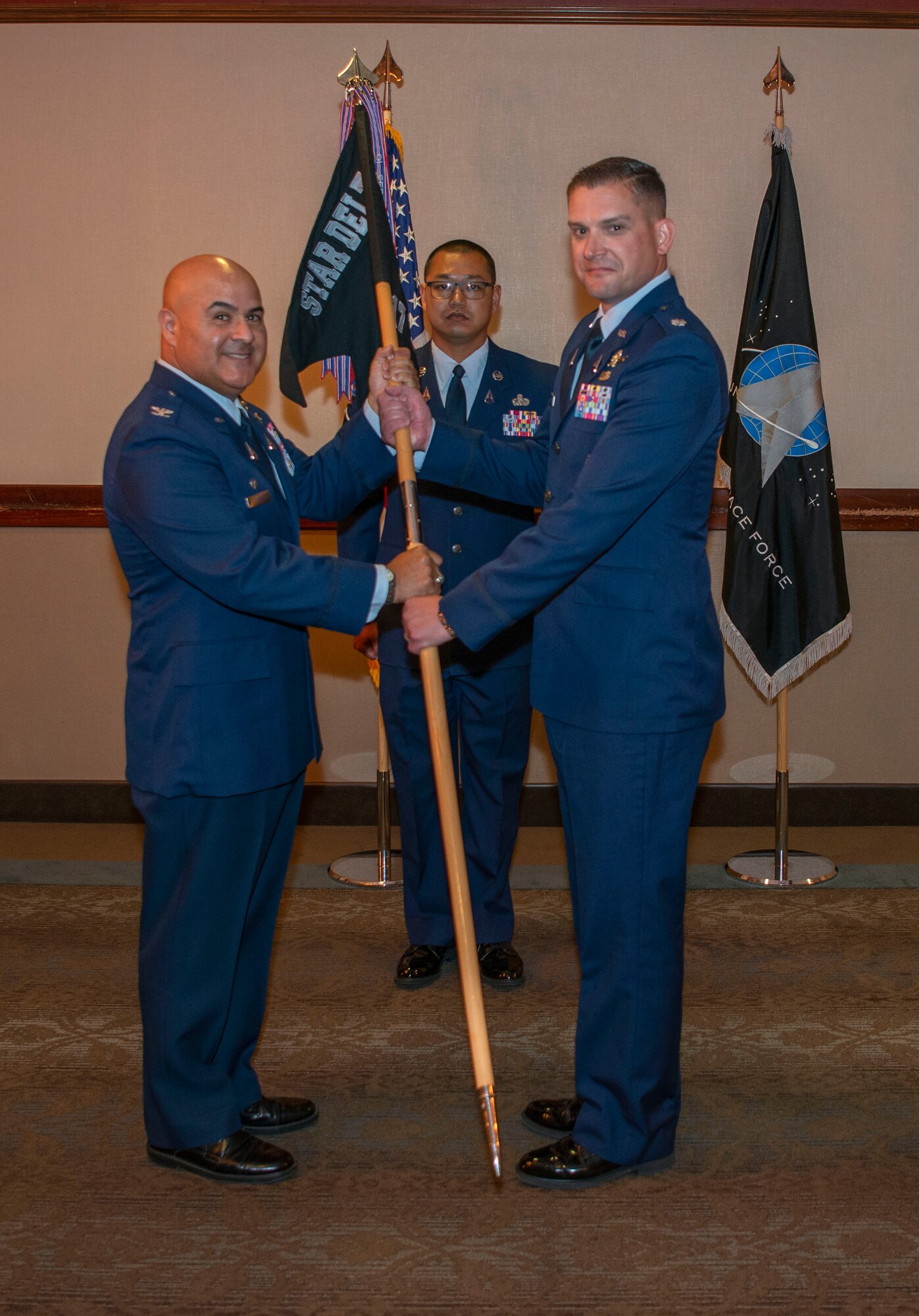 Two guardians pose for a photo holding a guidon