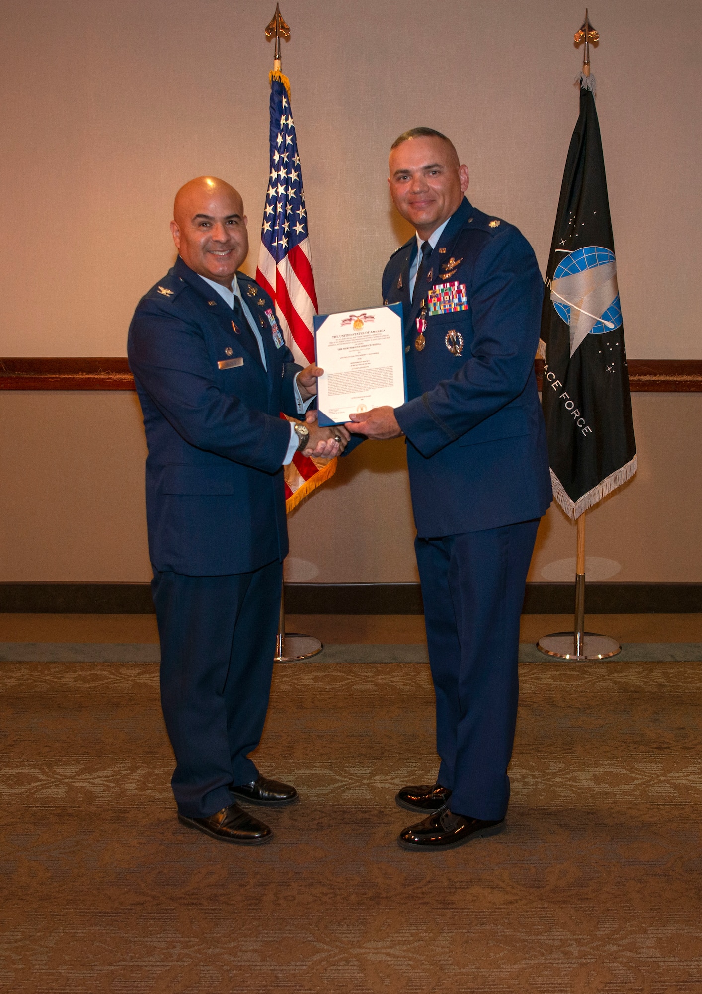 Two guardians pose for a photo holding a certificate