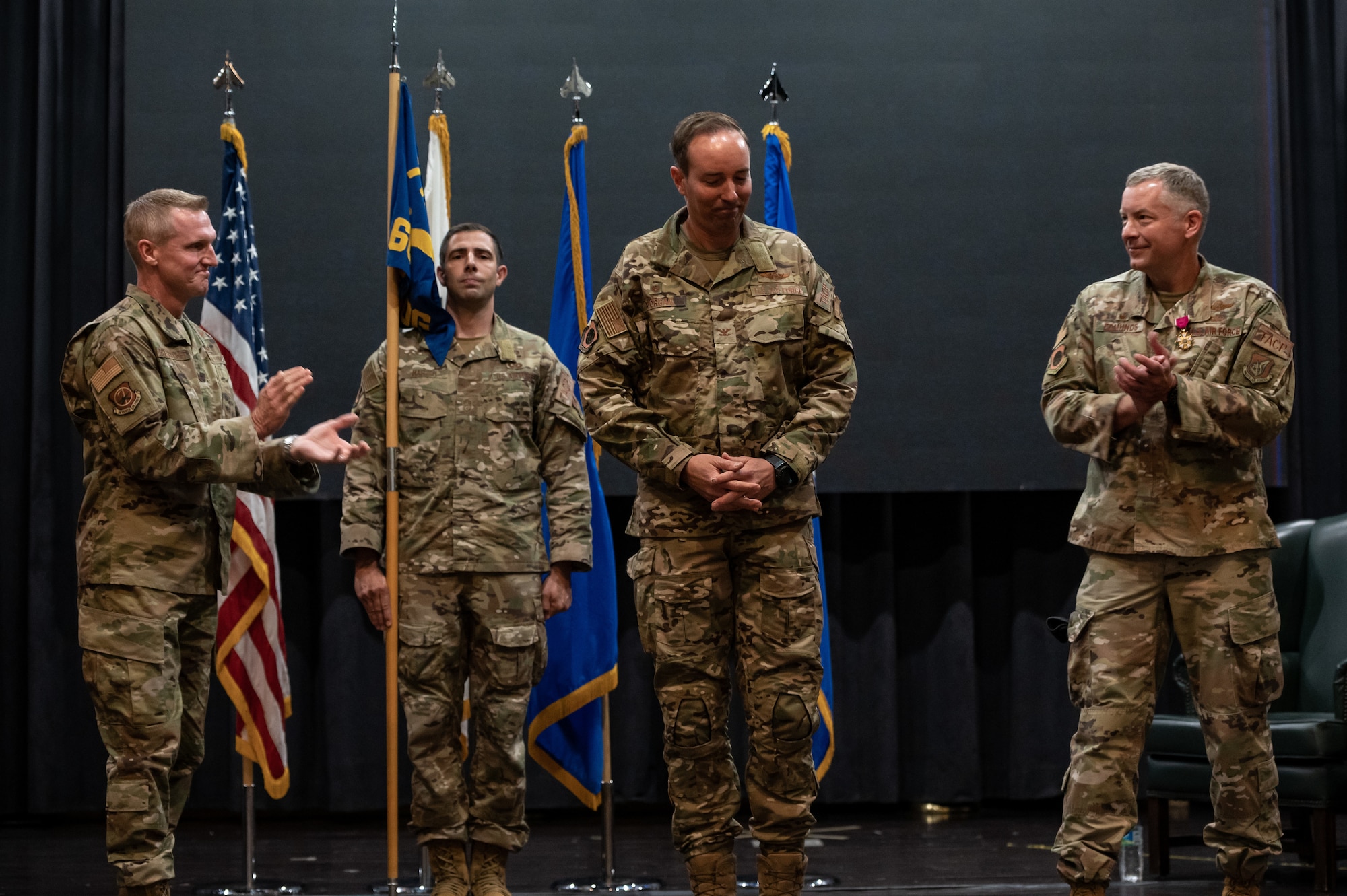 Brig. Gen. Jason Rueschhoff, 7th Air Force deputy commander, left, and Col. William Edmunds, 607th Air Support Operations Group outbound commander, right, congratulate Col. Scott Morgan, 607th ASOG commander at Osan Air Base, Republic of Korea, June 22, 202. With the passing of the guidon, Morgan begins his tenure as the commander of the 607th ASOG. (U.S. Air Force photo by Tech. Sgt. Nicholas Alder)
