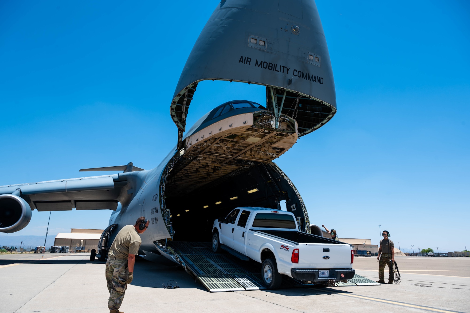 A truck is loaded onto a Dover Air Force Base C-5M Super Galaxy during a Major Command Service Tail Trainer at Holloman AFB, New Mexico, June 7, 2021. The 9th AS performs MSTTs to expedite upgrade and qualification training for C-5M loadmasters and flight engineers. This MSTT was coordinated in partnership with Air Education Training Command’s 49th Wing and Air Force Materiel Command’s 635th Materiel Maintenance Group. (U.S. Air Force photo by Senior Airman Faith Schaefer)