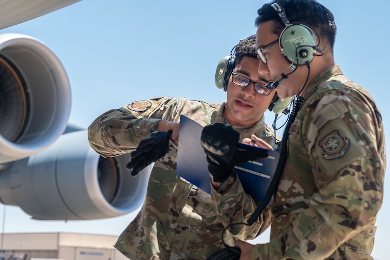 Senior Airman Edwin Vado, left, 436th Aircraft Maintenance Squadron flying crew chief, and Staff Sgt. Alex Delamarter, 9th Airlift Squadron student flight engineer, review an Engines Running Onload checklist for a Dover Air Force Base C-5M Super Galaxy during a Major Command Service Tail Trainer at Holloman AFB, New Mexico, June 7, 2021. The 9th AS performs MSTTs to expedite upgrade and qualification training for C-5M loadmasters and flight engineers.(U.S. Air Force photo by Senior Airman Faith Schaefer)